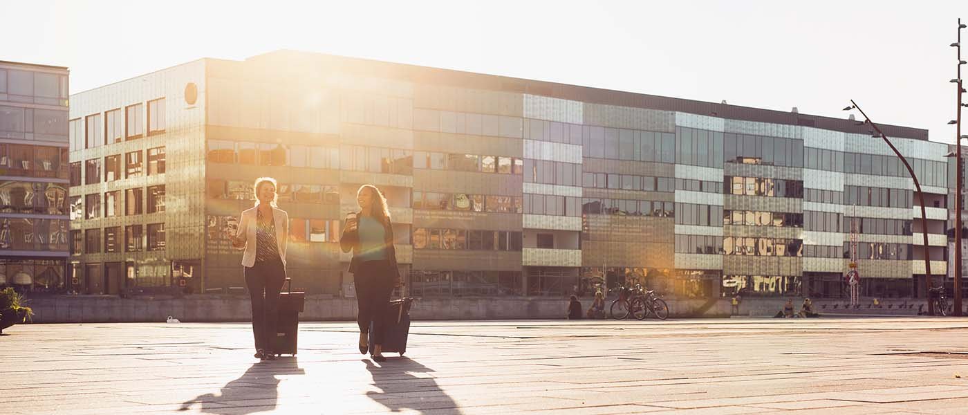 Two women walking in Malmö city by the sunset