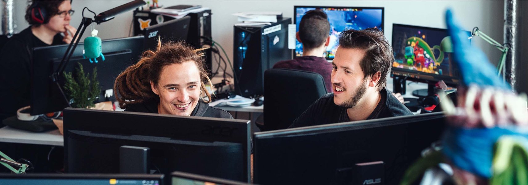 Four people sitting in a games office 