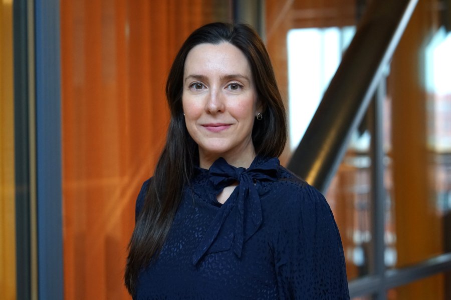 Porträtt av en kvinna som ler in i kamera. Hon bär en svart tröja.