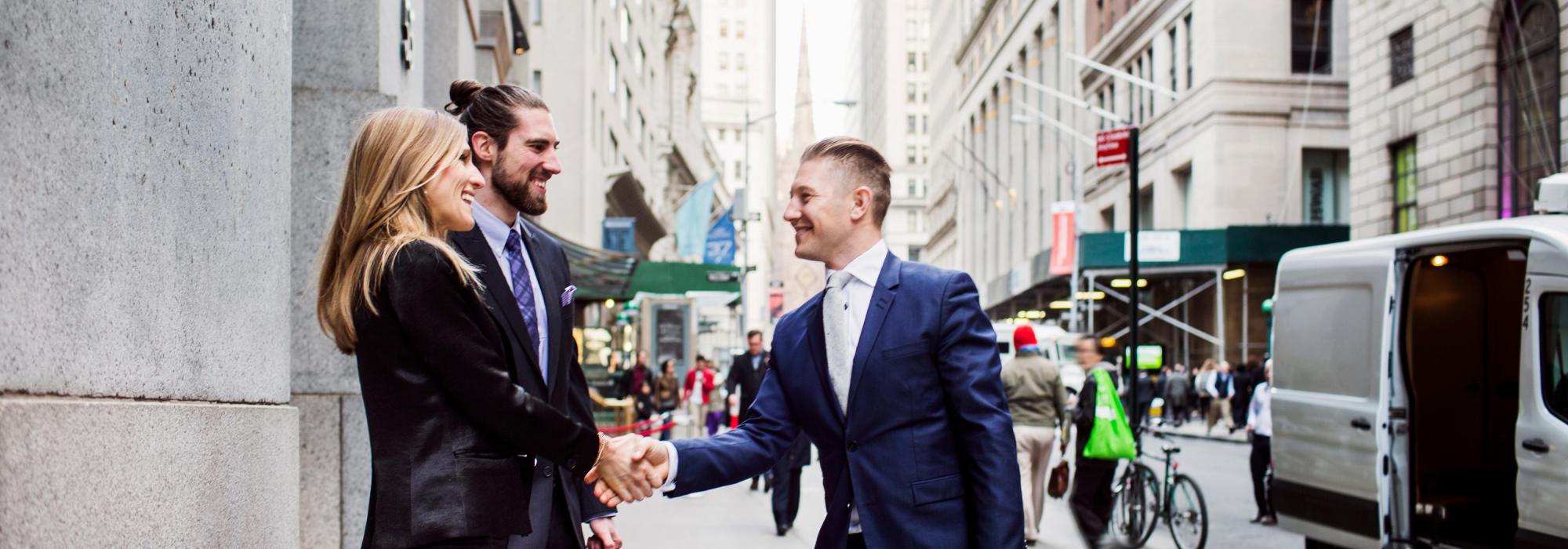 Two persons in busy city street sharing hands