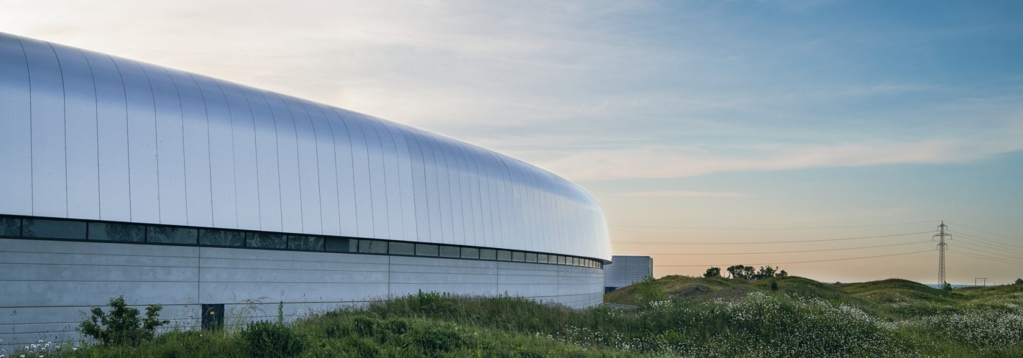 A white futuristic building in a landscapa captured in the sunset 