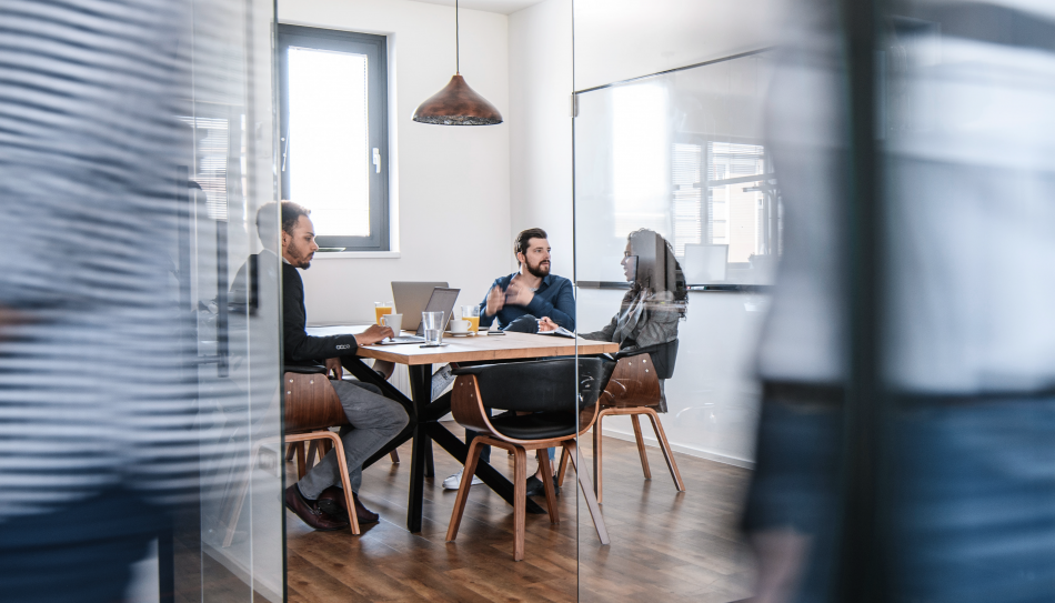 Three people having a meeting by a table