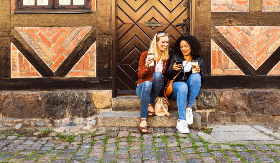 two persons sitting at a staircase