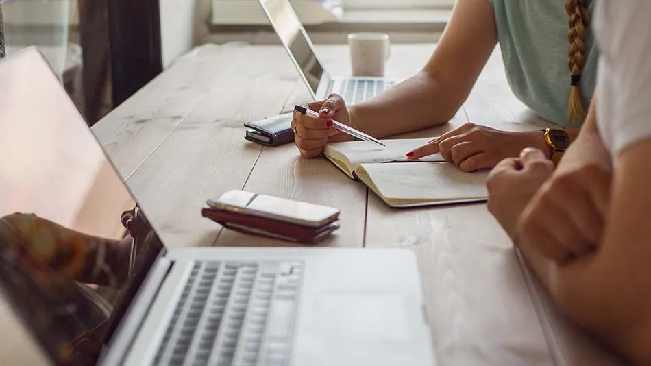 Two persons working by a desk 
