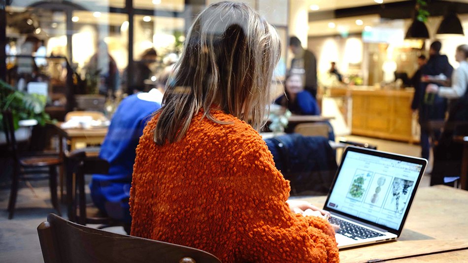 Gil sitting at a cafe working on a laptop