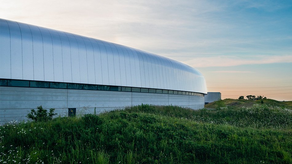 A white futuristic building in a landscape during sunset