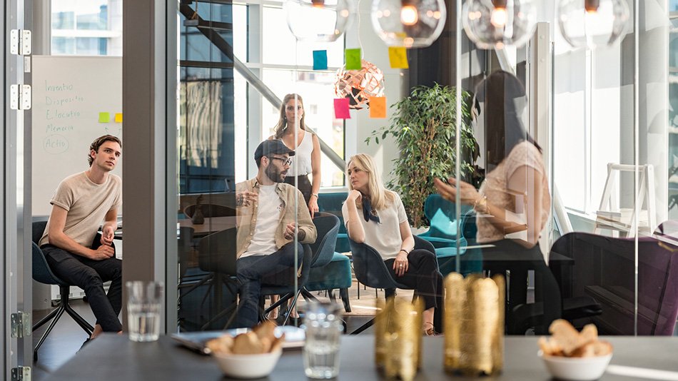 Modern office environment. Five colleagues having an informal meeting.