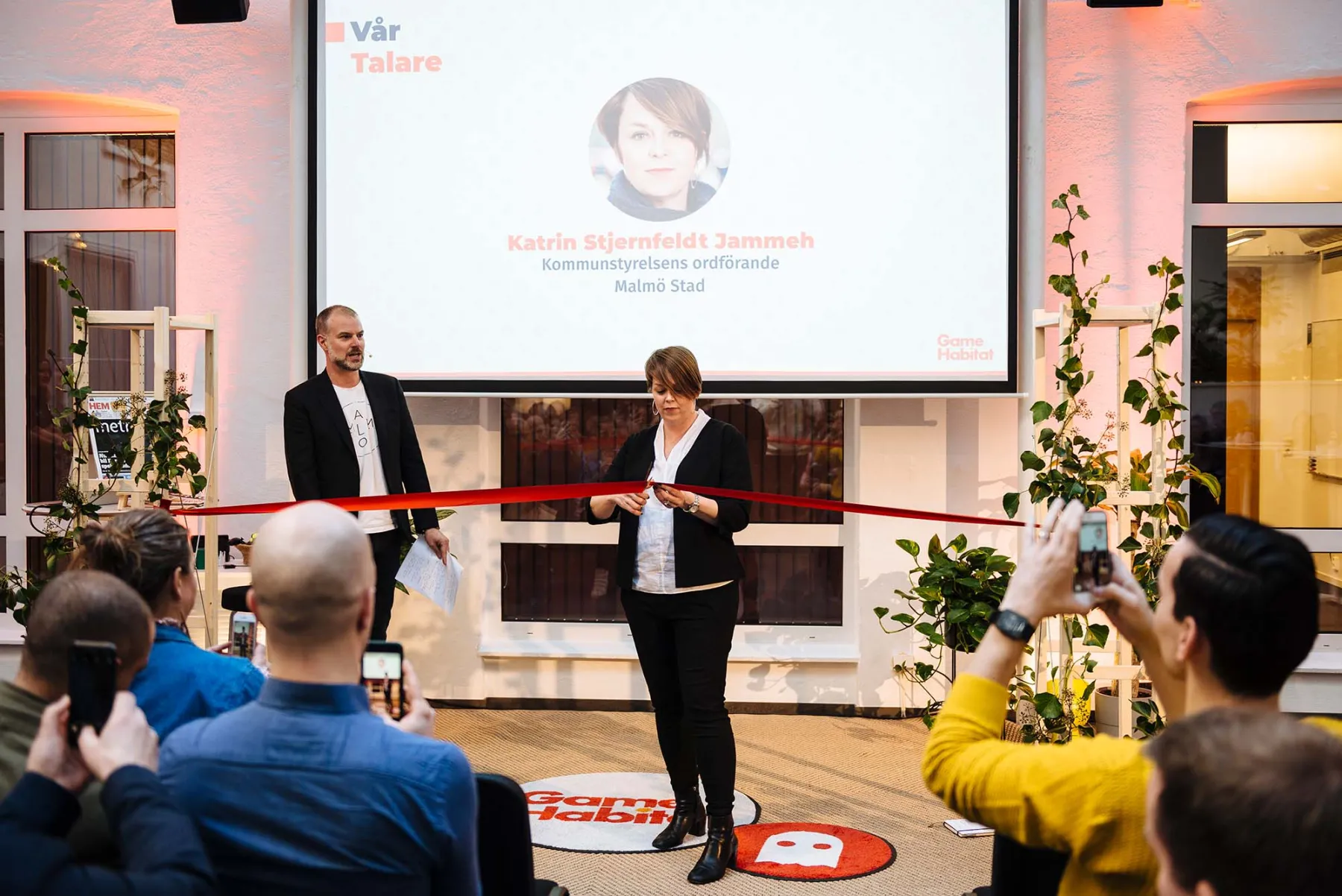 A woman cutting a ribbon at an event