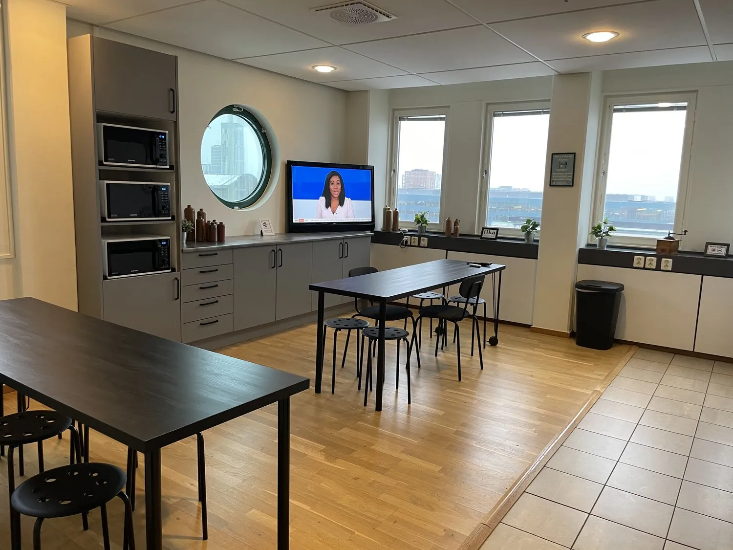 A picture of a canteen with table, chairs and microwaves