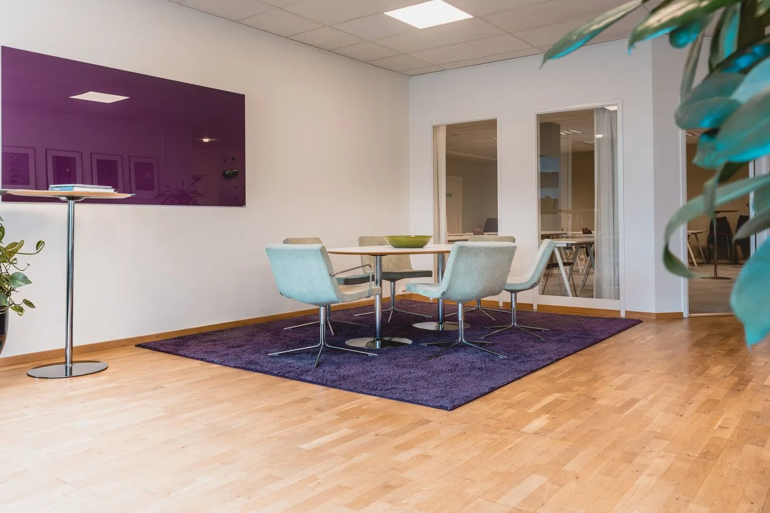 A meeting area with table, charis and a big screen