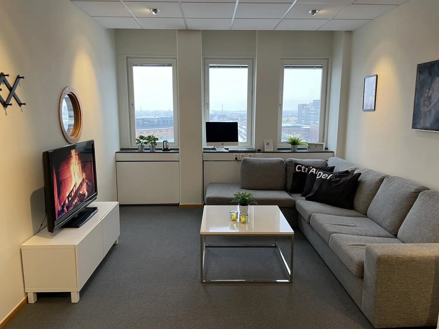 A lounge area with a TV, table and couch