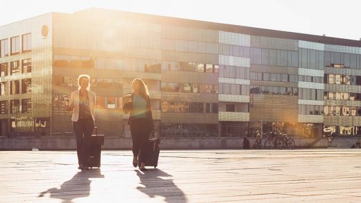 Two women walking in Malmö city by the sunset